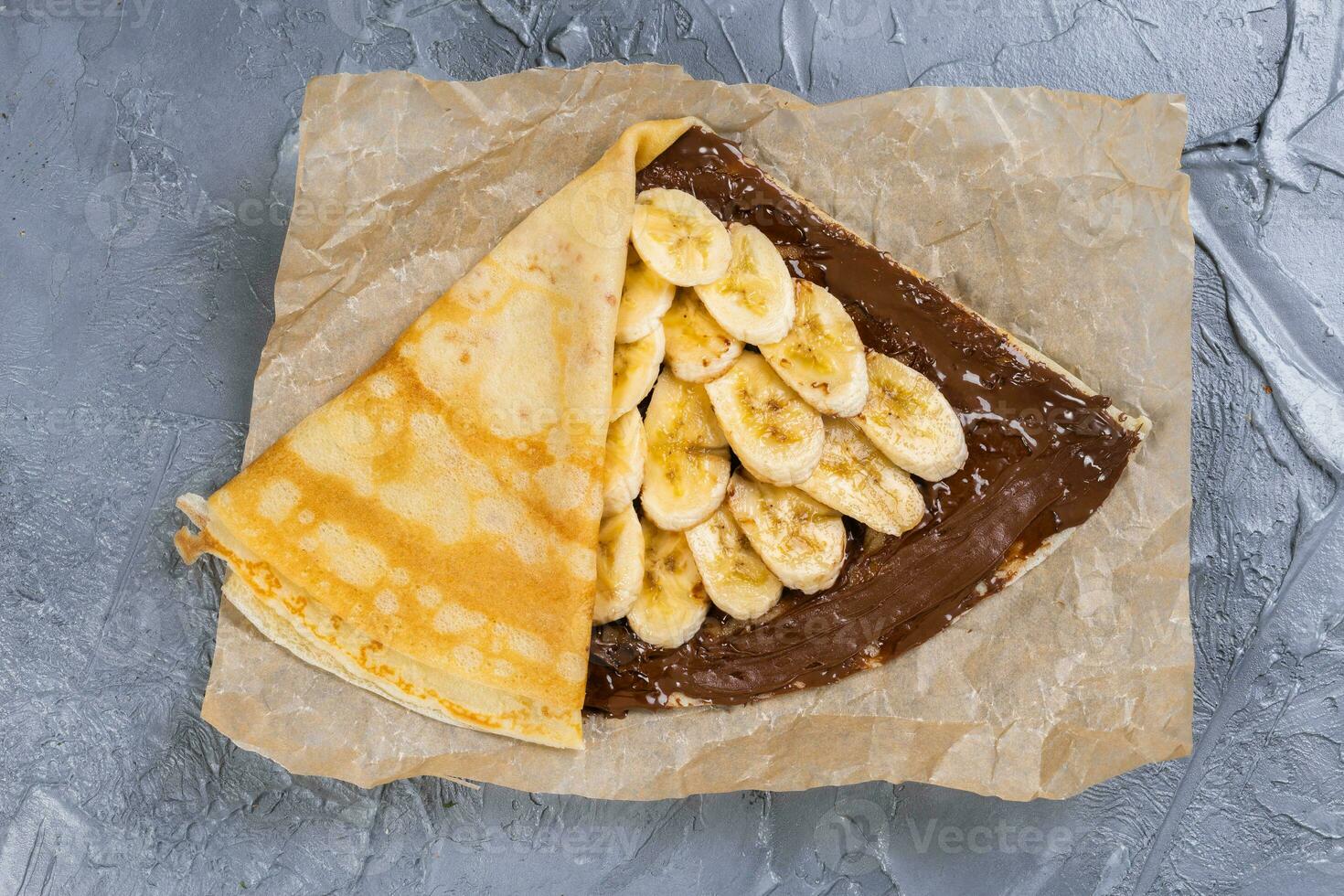 crepes recheado com chocolate espalhar e banana. fino panquecas. doce sobremesa. francês cozinha topo Visão foto