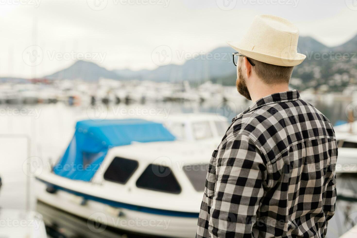 traseiro Visão homem vestindo chapéu com iates e marina fundo com cópia de espaço e esvaziar Lugar, colocar para publicidade foto