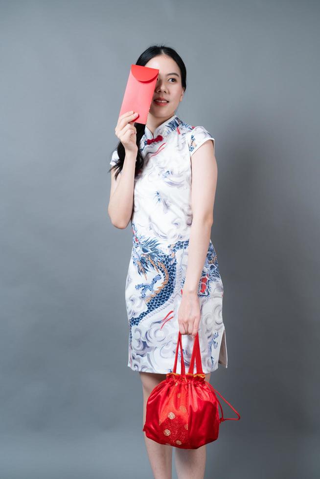 mulher asiática usa vestido tradicional chinês com envelope vermelho ou pacote vermelho foto