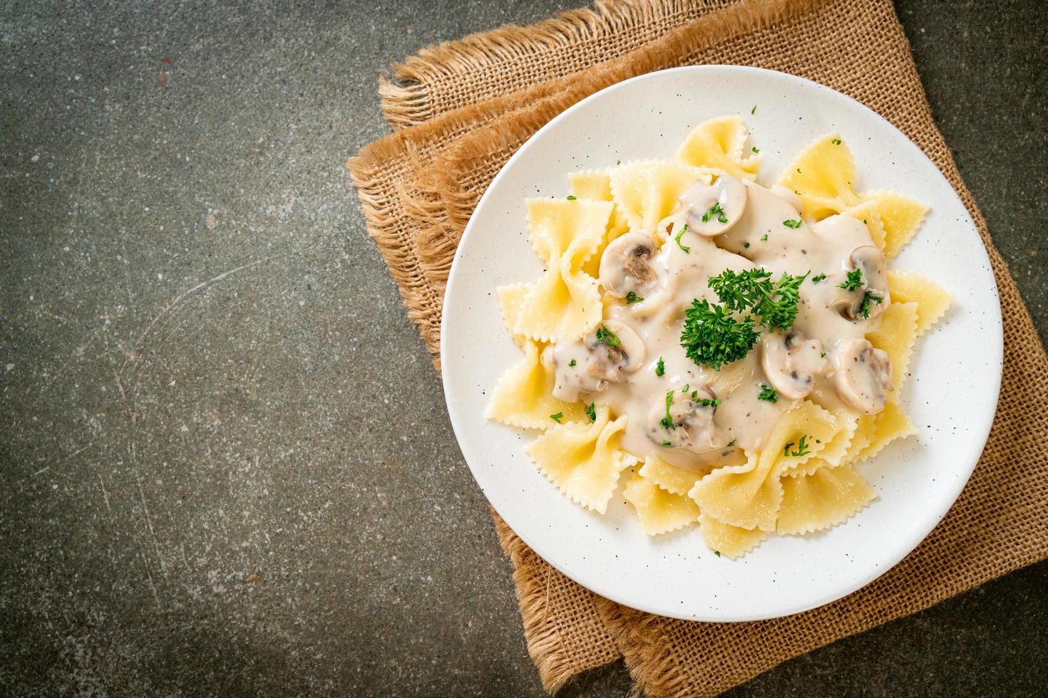 macarrão farfalle com molho de creme de cogumelos branco - comida italiana foto