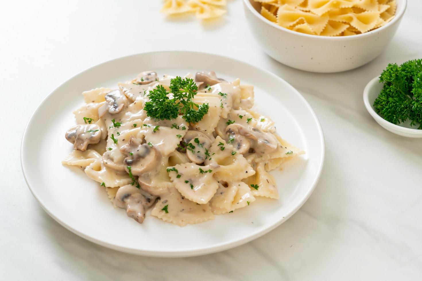 macarrão farfalle com molho de creme de cogumelos branco - comida italiana foto