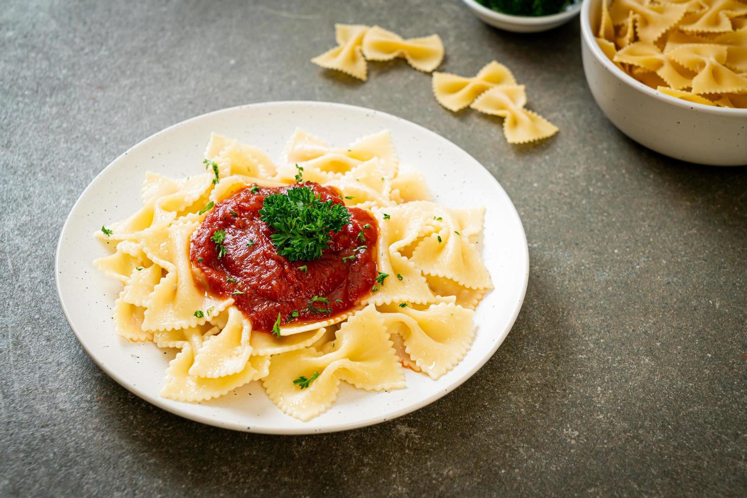 macarrão farfalle em molho de tomate com salsa - comida italiana foto