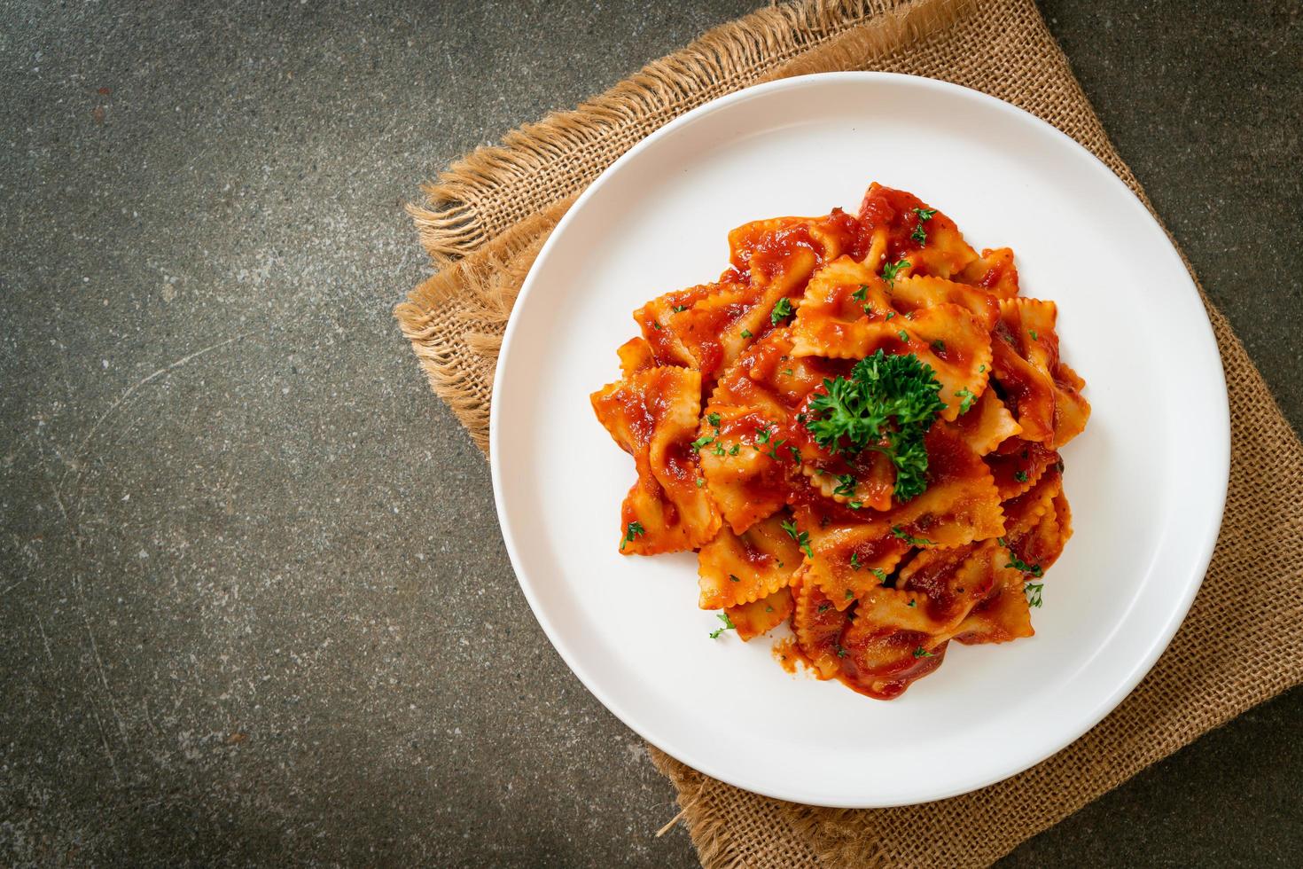 macarrão farfalle em molho de tomate com salsa - comida italiana foto