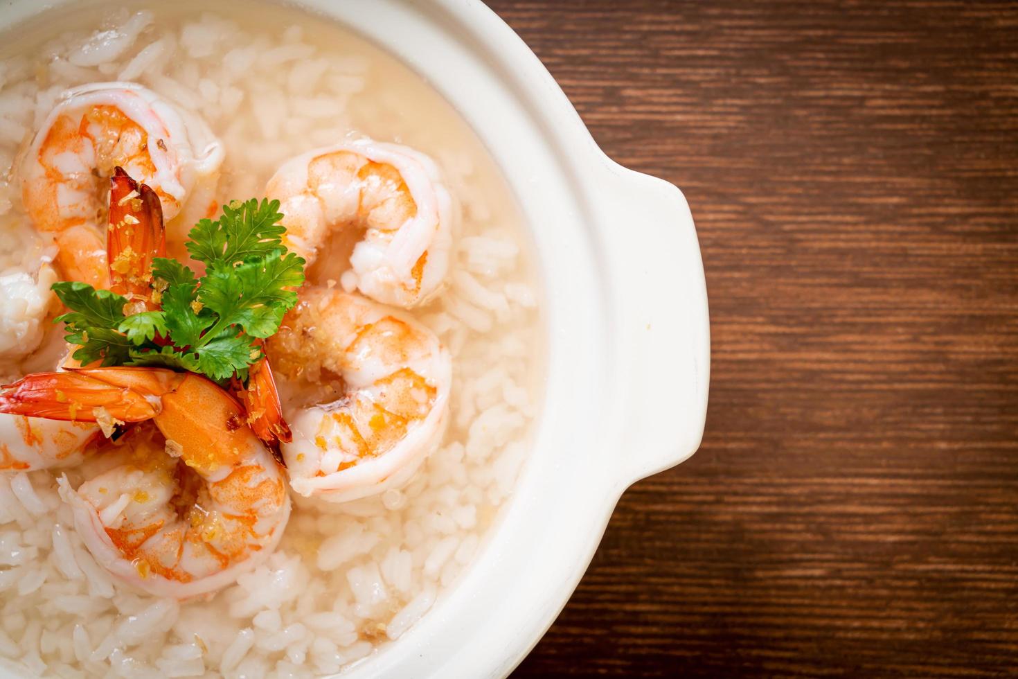 mingau ou sopa de arroz cozido com tigela de camarão foto