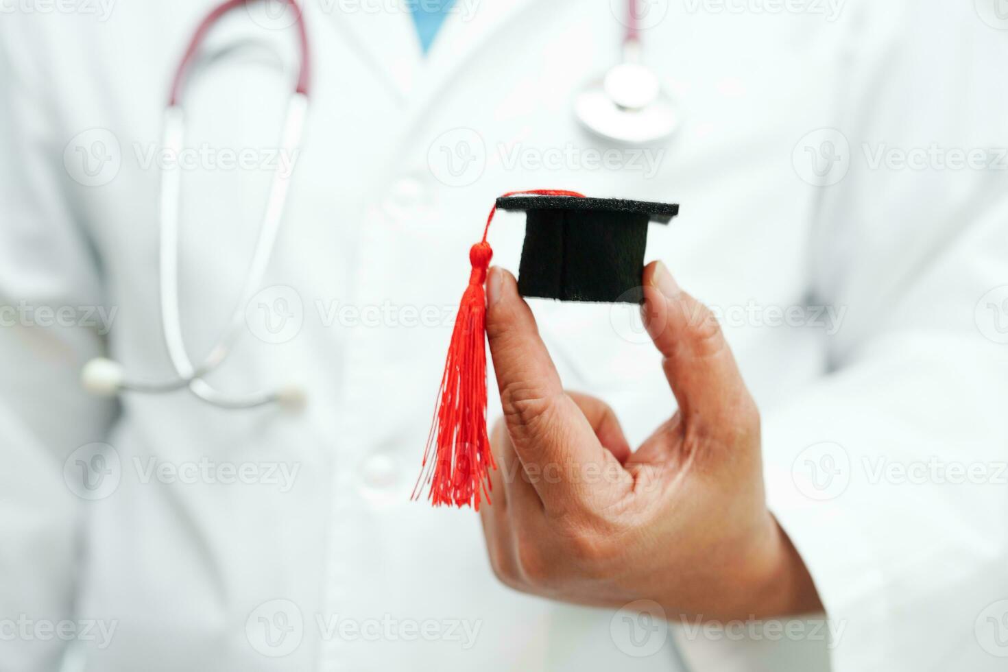 médico de mulher asiática segurando o chapéu de formatura no hospital, conceito de educação médica. foto