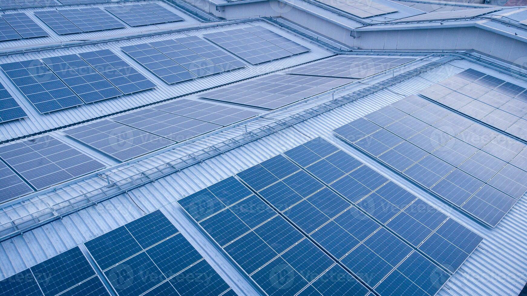 futuro verde energia e sustentável eletricidade recurso conceito. ao ar livre foco em solar painéis em telhados ou energia fotovoltaica do fábricas de drone. industrial cobertura com solar célula rede com azul tom. foto