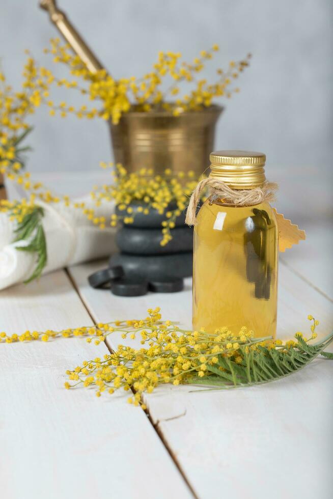 mimosa flores massagem óleo dentro vidro garrafa. foto