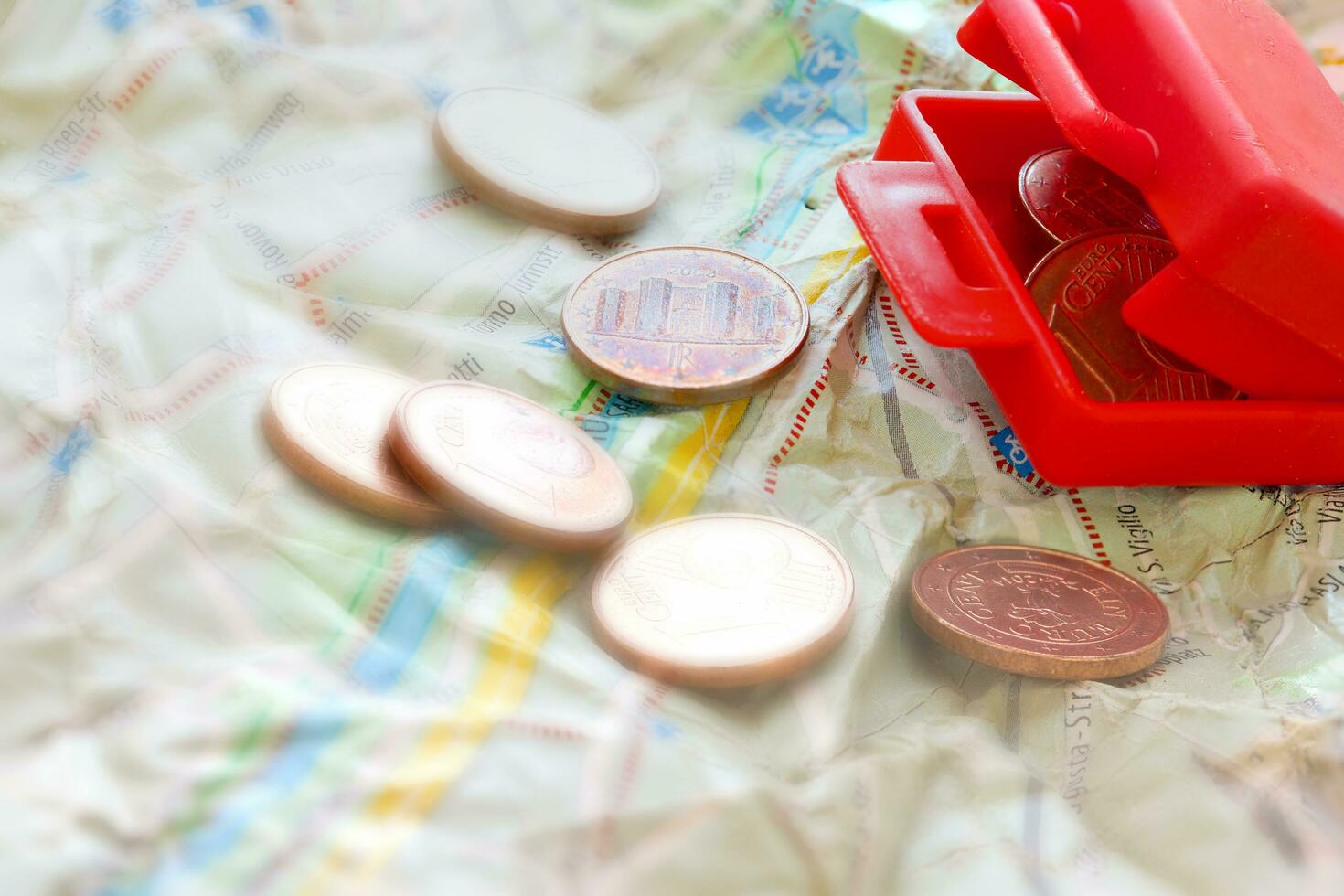 mini vermelho mala de viagem com euro moedas em uma mapa foto