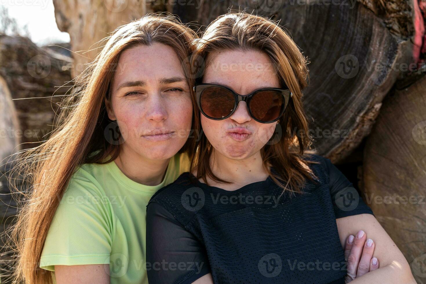 casal do bonita amigáveis mulheres levando uma selfie fazer engraçado rostos foto