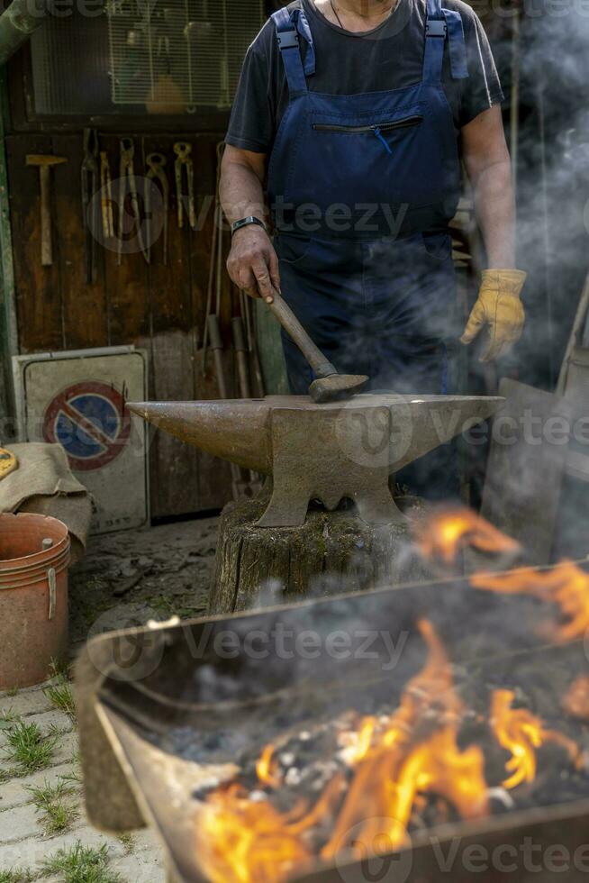 ferreiro é queimando uma metal Barra para dar isto uma Novo forma foto