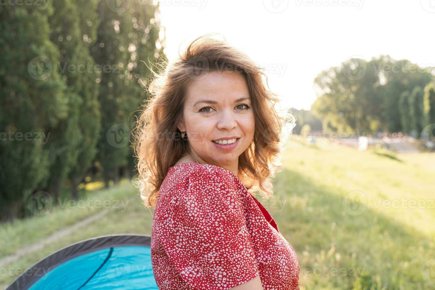 retrato do jovem mãe com vermelho vestir ao ar livre foto