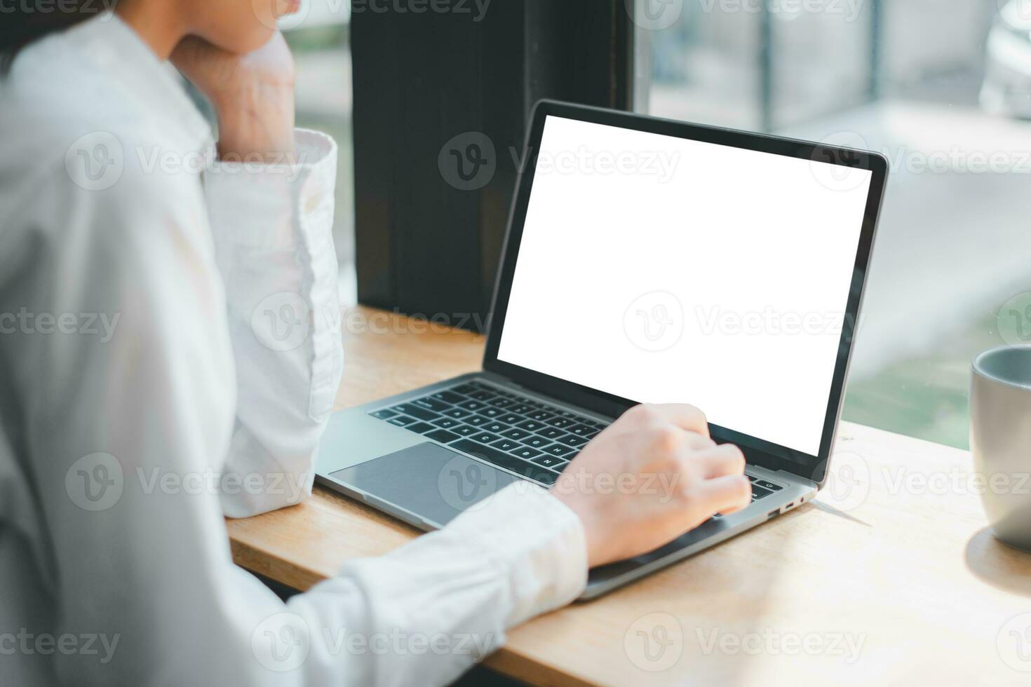 fechar-se costas Visão do uma o negócio mulher trabalhando em em branco tela computador portátil computador, olhando às a tela. escritório trabalhador usando uma caderno computador. foto