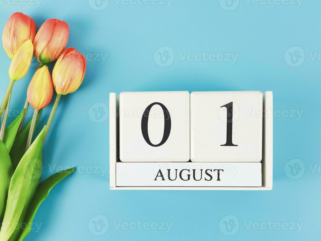 plano deitar do de madeira calendário com encontro agosto 01 em azul fundo com laranja e amarelo tulipas, cópia de espaço. foto