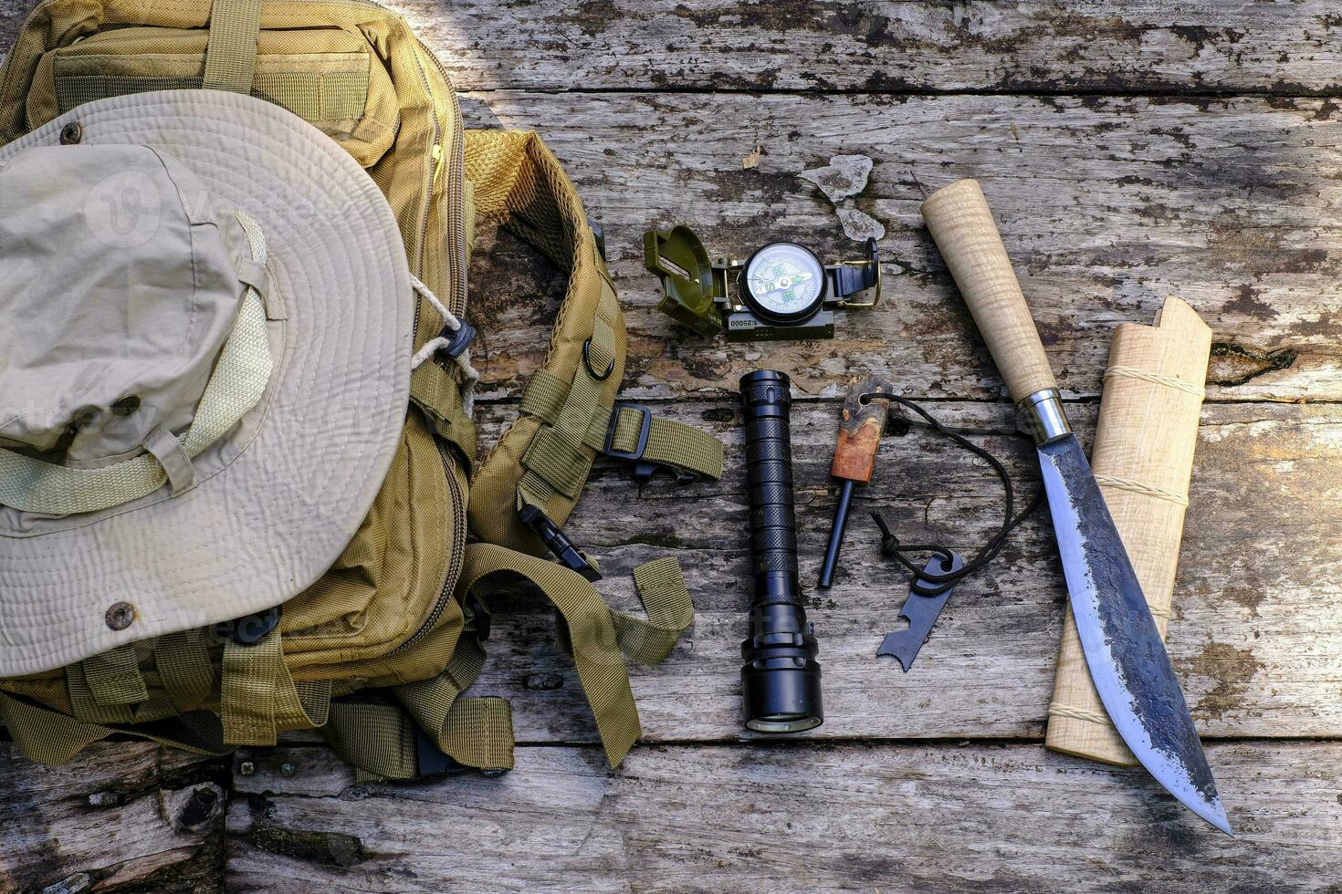 faca mochila com equipamento para sobrevivência dentro a floresta em a velho de madeira fundo foto