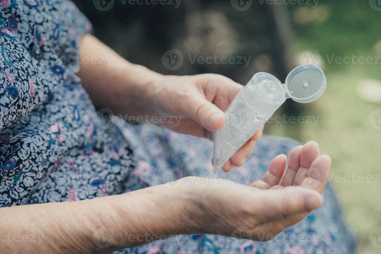 paciente asiático sênior ou idosa lavando as mãos com álcool gel desinfetante para proteger a infecção de segurança e matar o coronavírus covid-19, bactérias e germes. foto