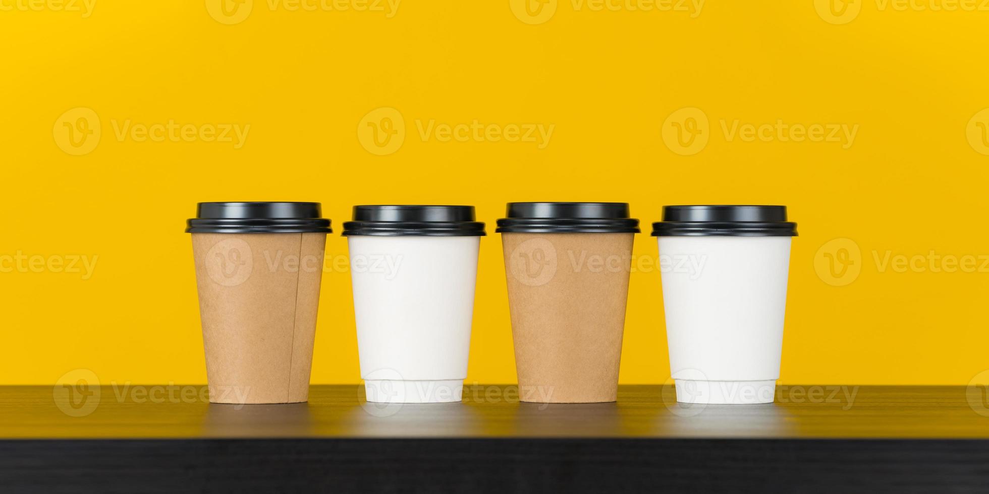 xícara de café de papel em branco em fundo amarelo foto