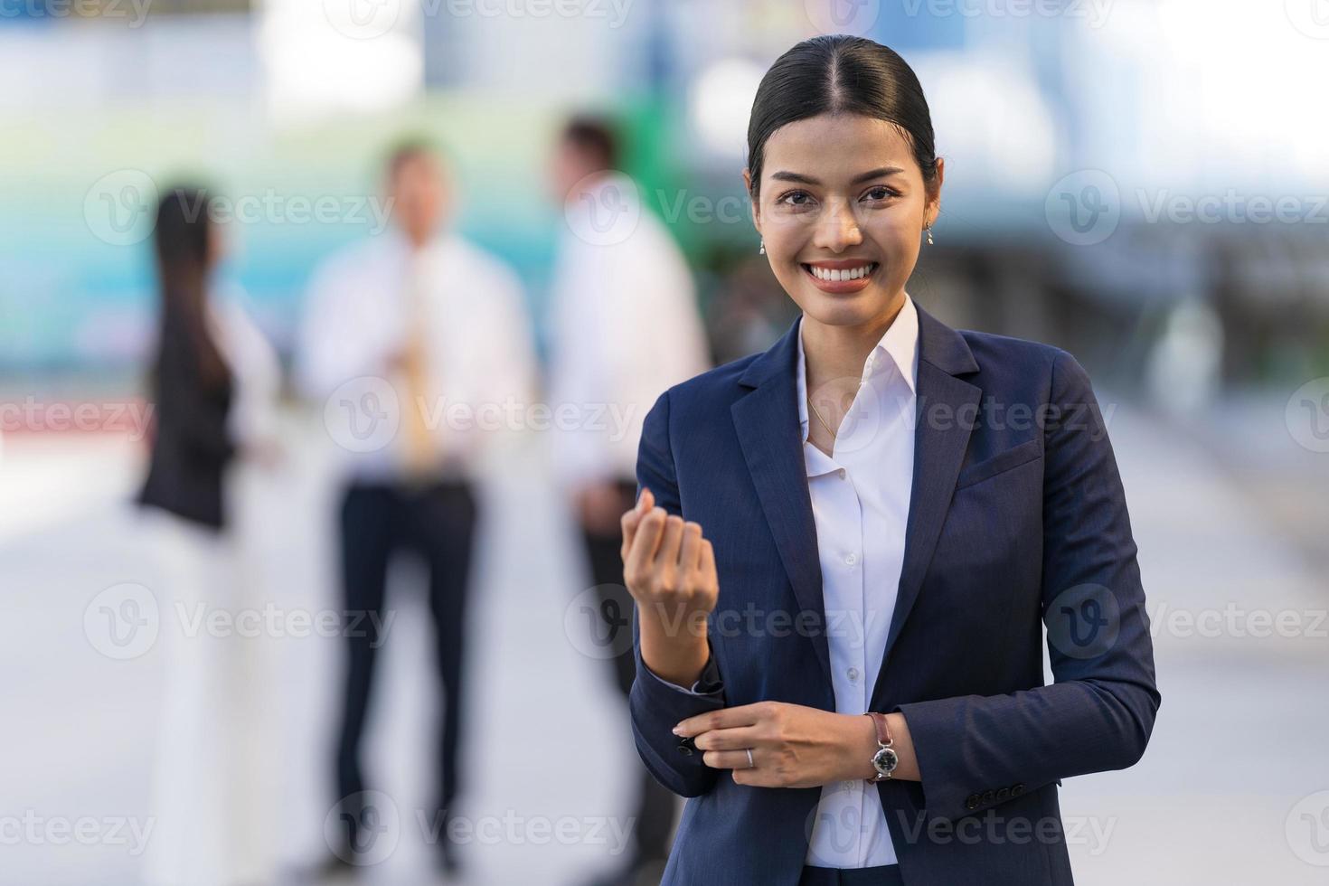 retrato de mulher de negócios sorridente em frente a edifícios de escritórios modernos foto