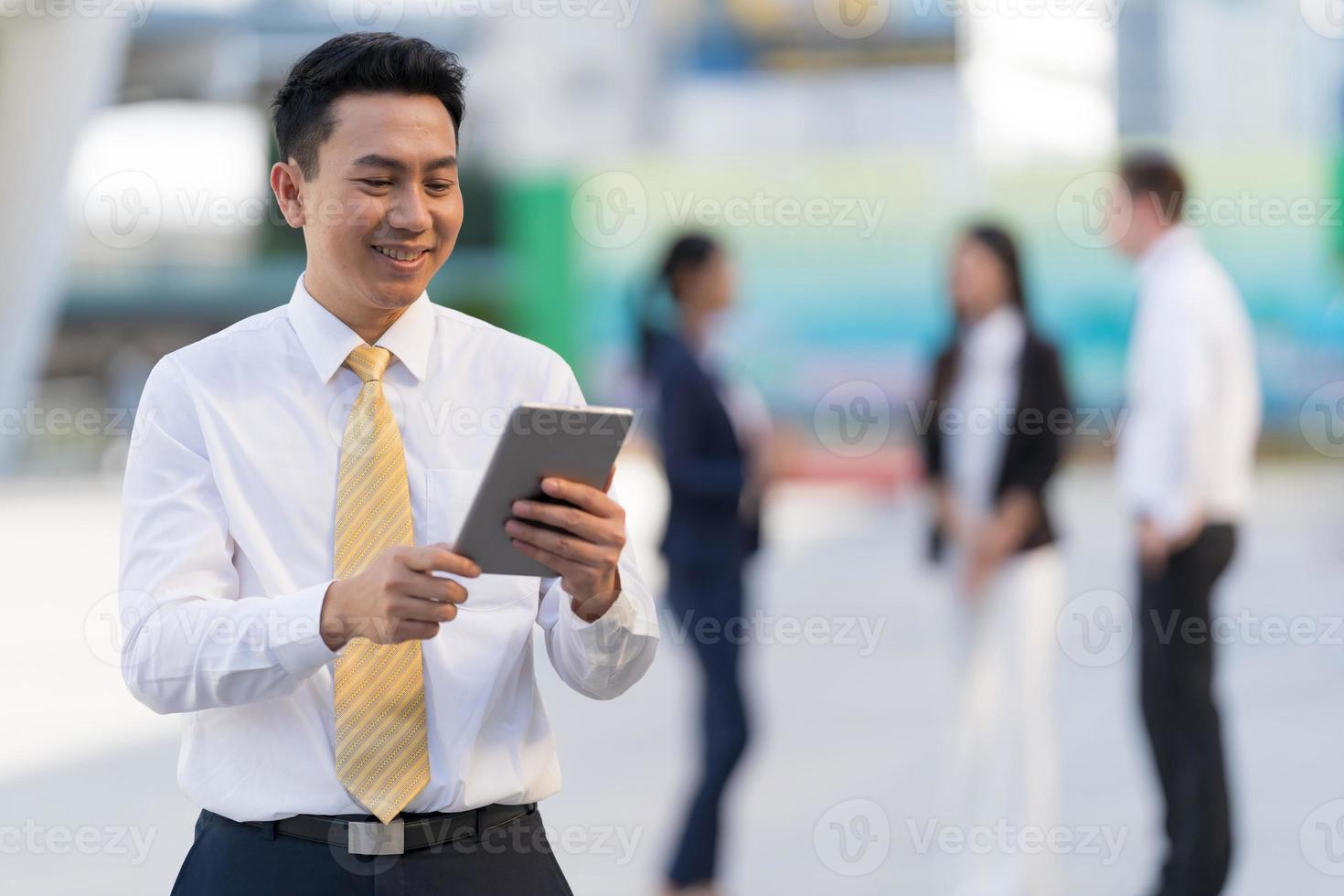 retrato de empresário sorridente, olhando para o tablet foto