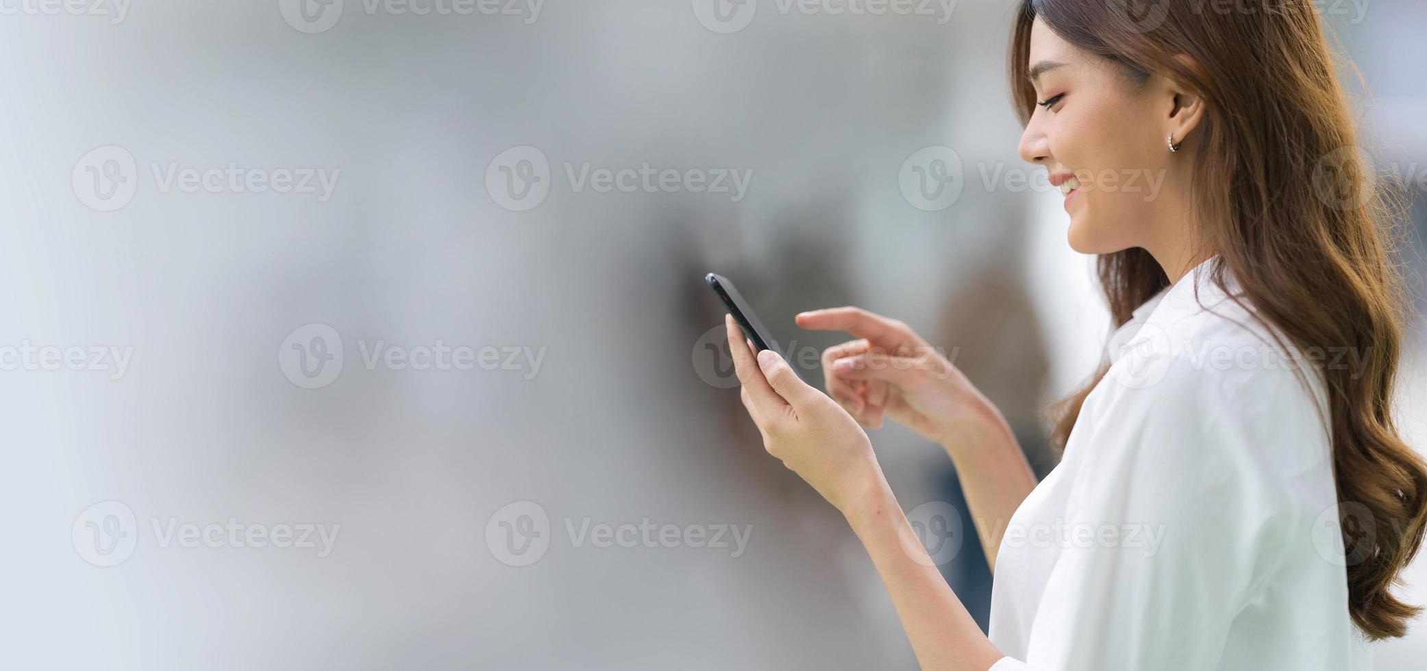 retrato ao ar livre de uma jovem feliz usando um telefone foto