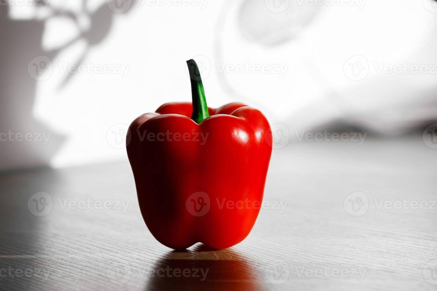 pimenta vermelha fresca em uma mesa com a luz do sol da janela da cozinha foto