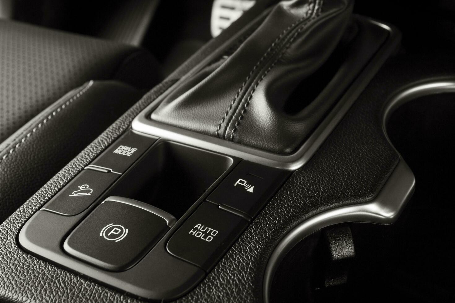 eletrônico travão de mão botão em uma Novo carro com luxuoso e moderno detalhes foto