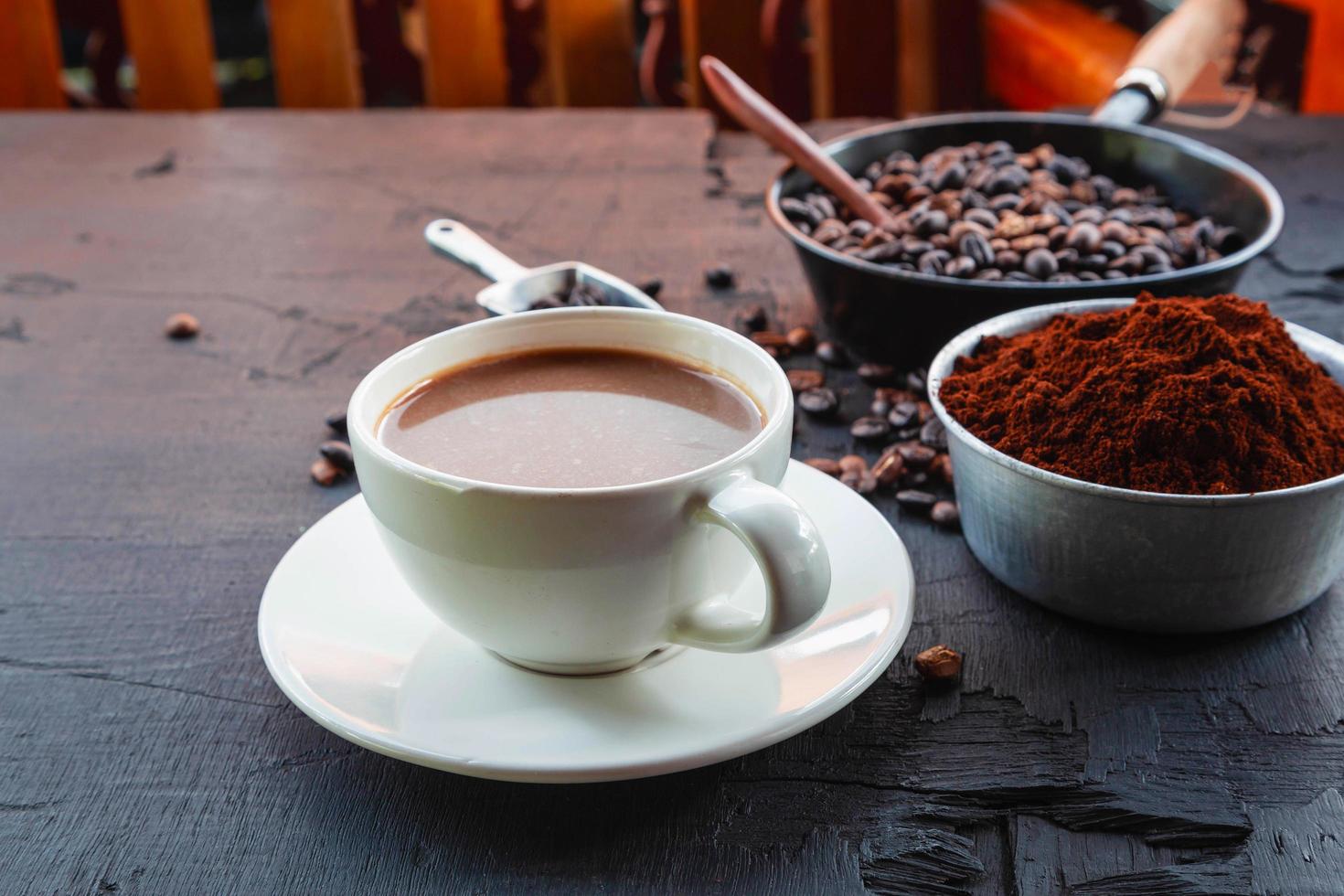 grãos de café torrados com pó de café e xícaras de café. foto