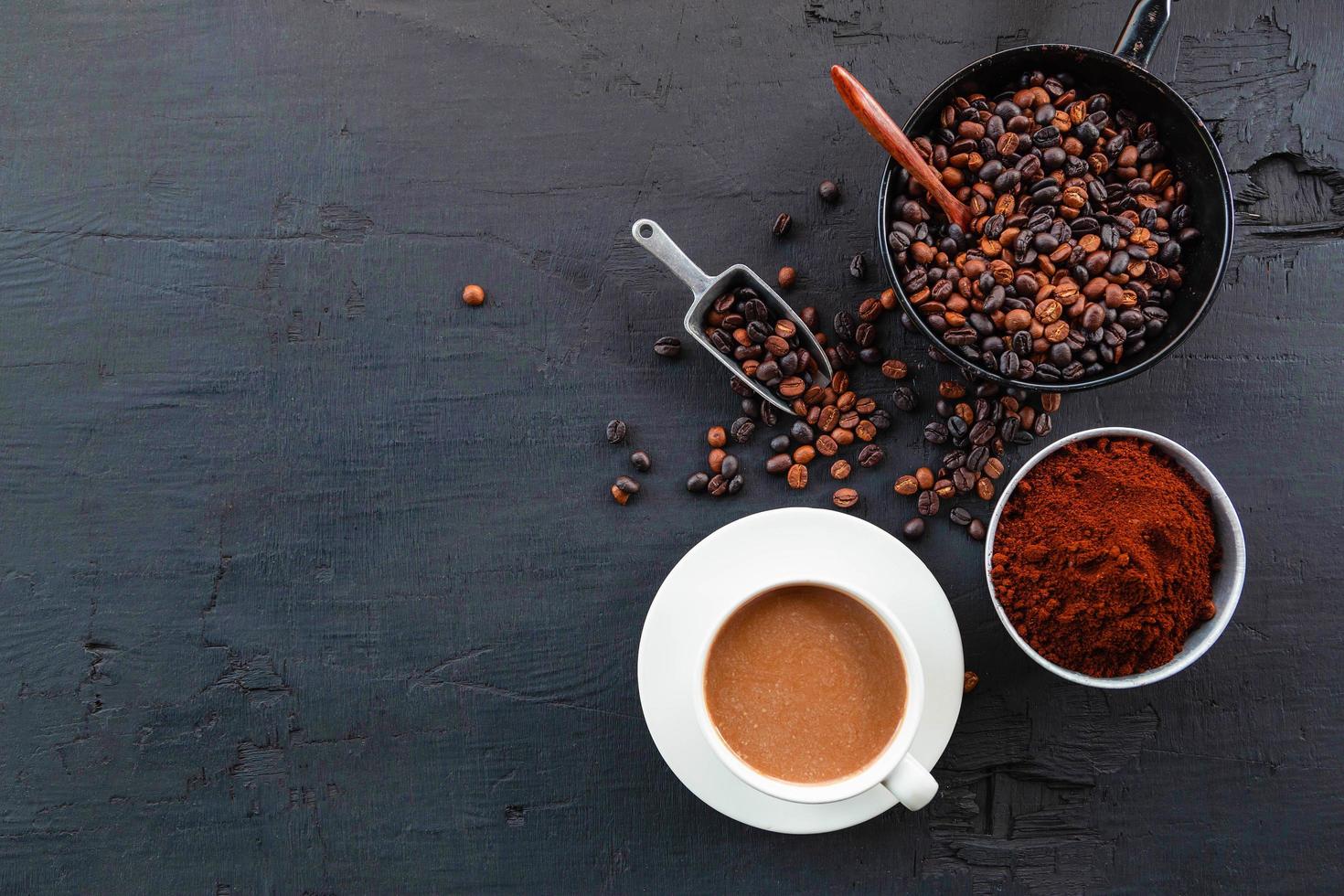 grãos de café torrados com pó de café e xícaras de café. foto