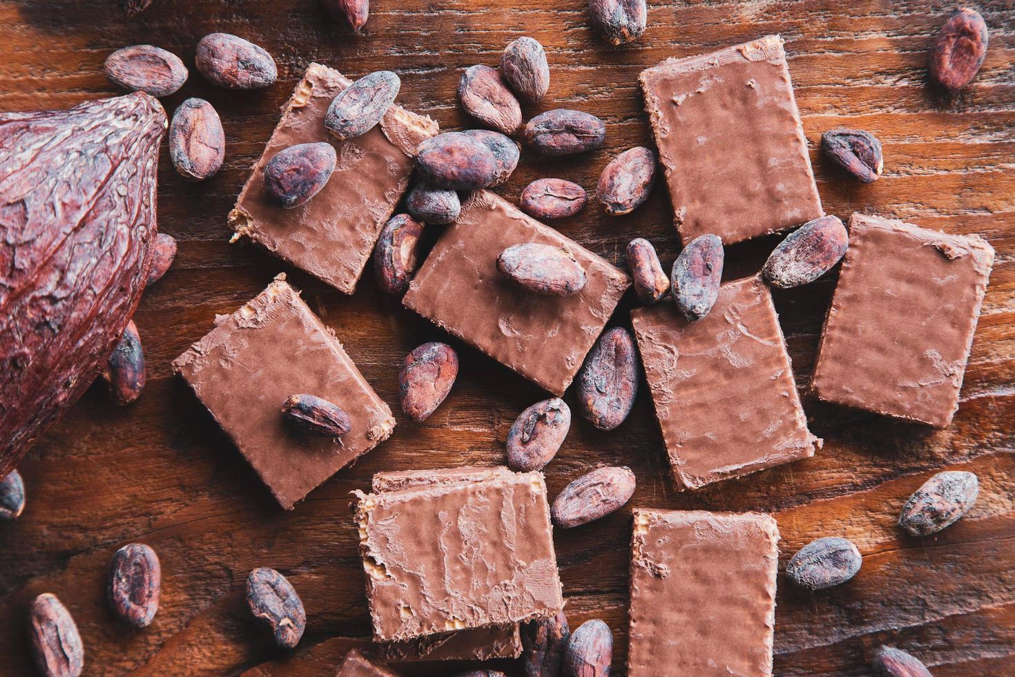 grãos de chocolate e cacau com cacau em um fundo preto foto