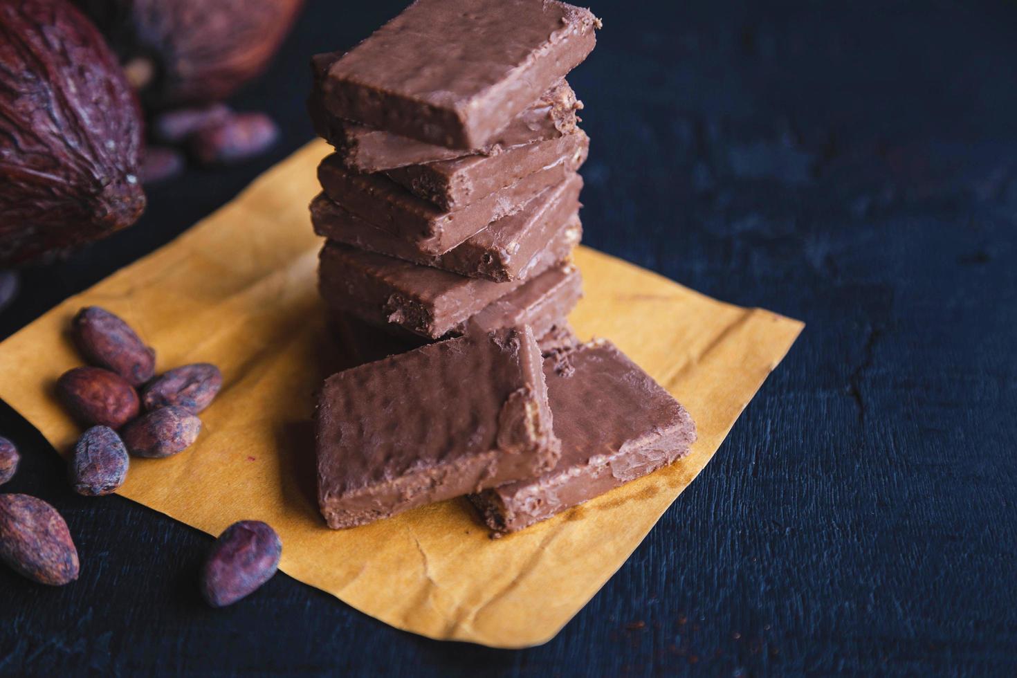 grãos de chocolate e cacau com cacau em um fundo preto foto