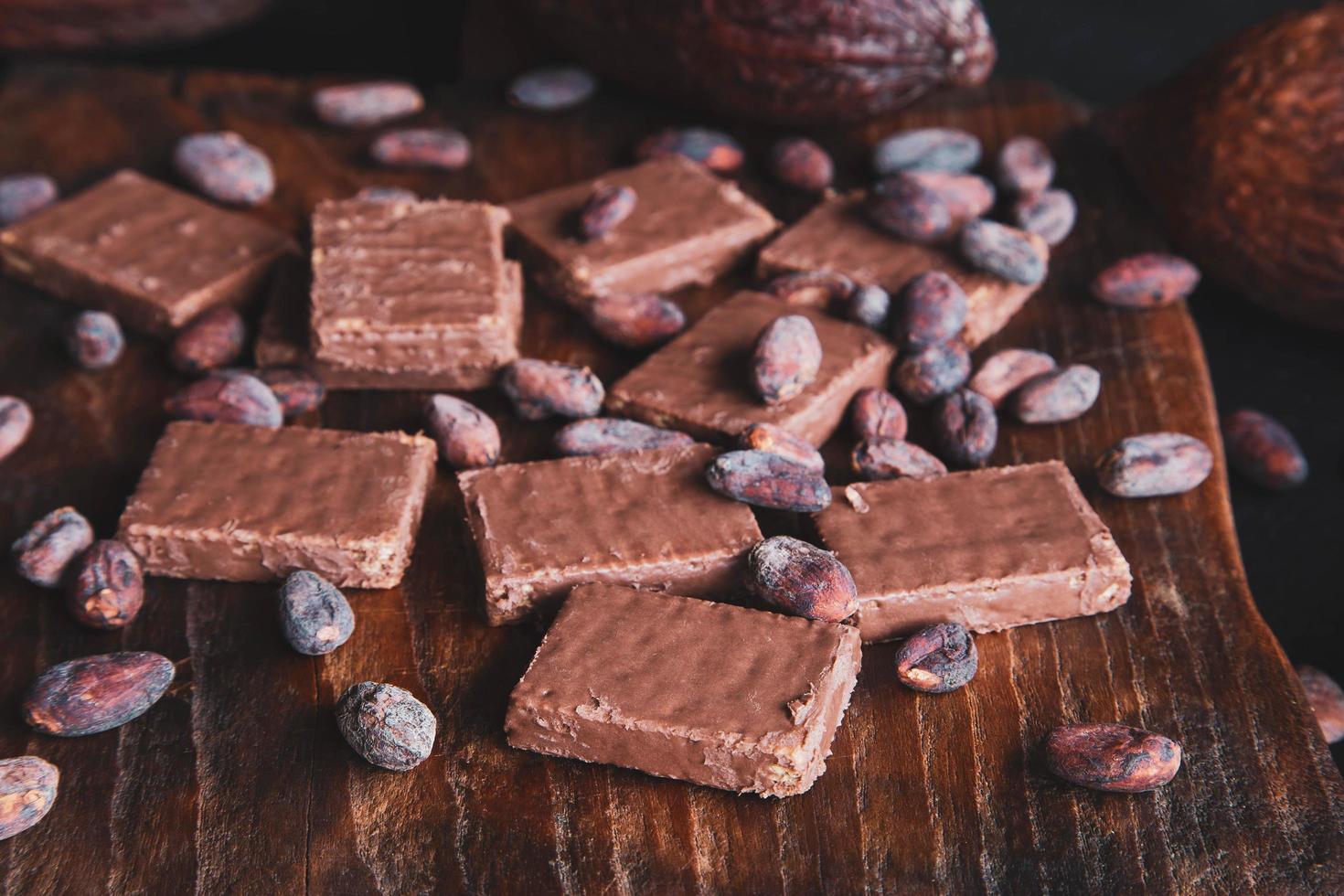 grãos de chocolate e cacau com cacau em um fundo preto foto