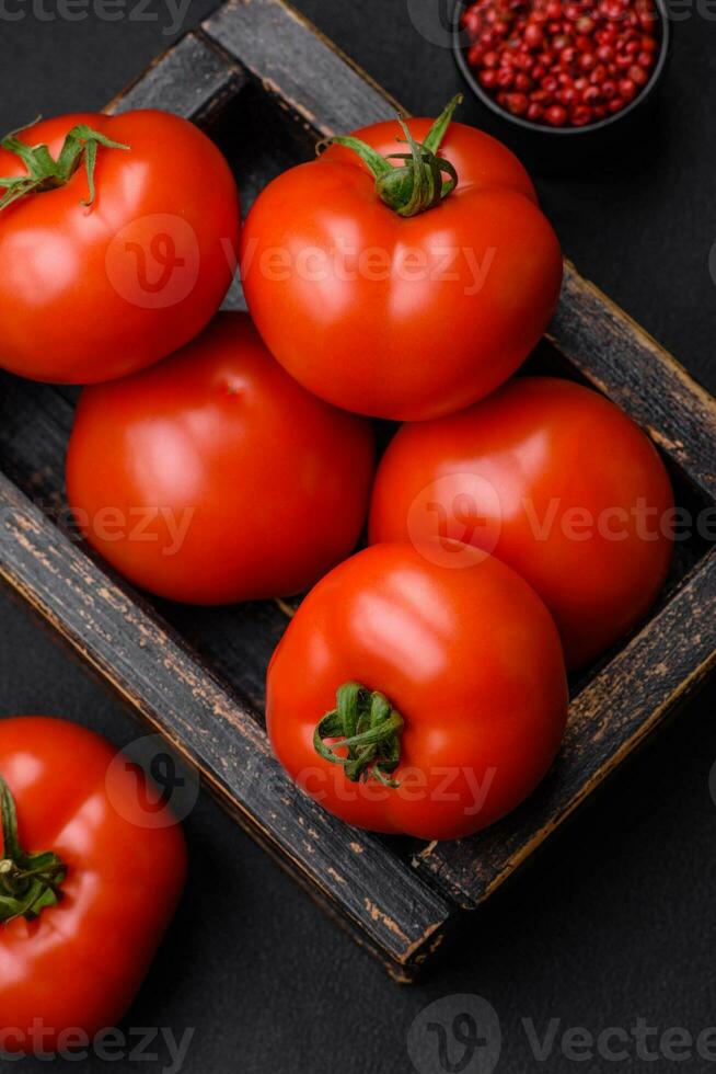 delicioso fresco suculento tomates em uma Sombrio concreto fundo foto