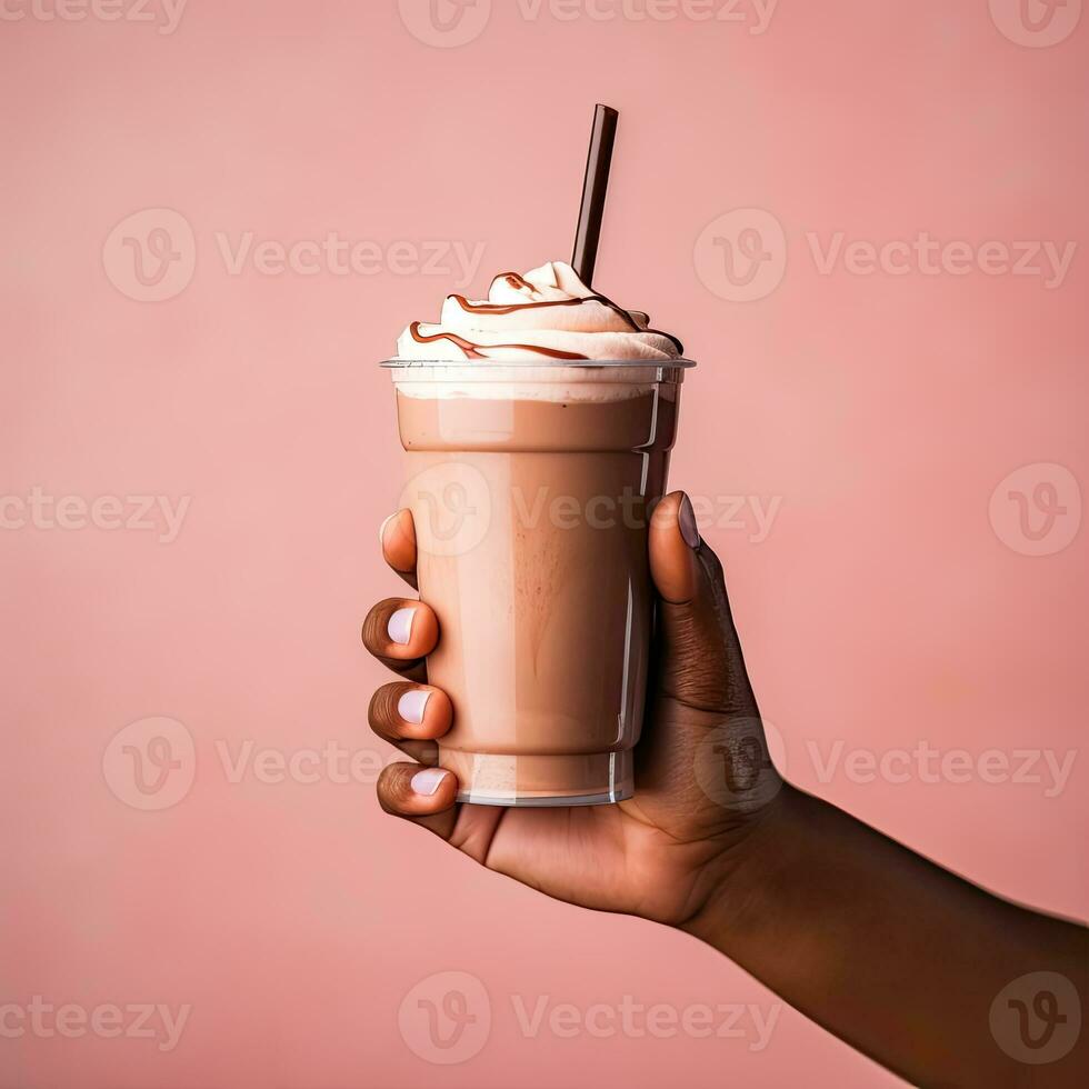 fechar-se do fêmea mão segurando vidro do chocolate milkshake com açoitado creme em Rosa fundo foto