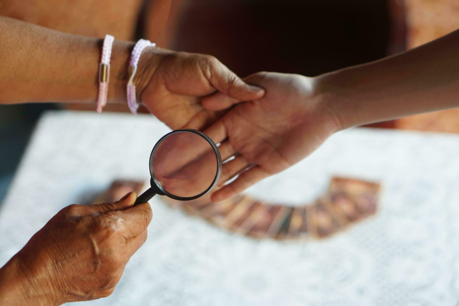 a mão do close up segura a lupa para inspecionar as linhas da palma. conceito, quiromancia, astrologia. predição, mistério, magia, fortuna, destino. previsão para a vida futura, eventos. previsão quiromante. foto