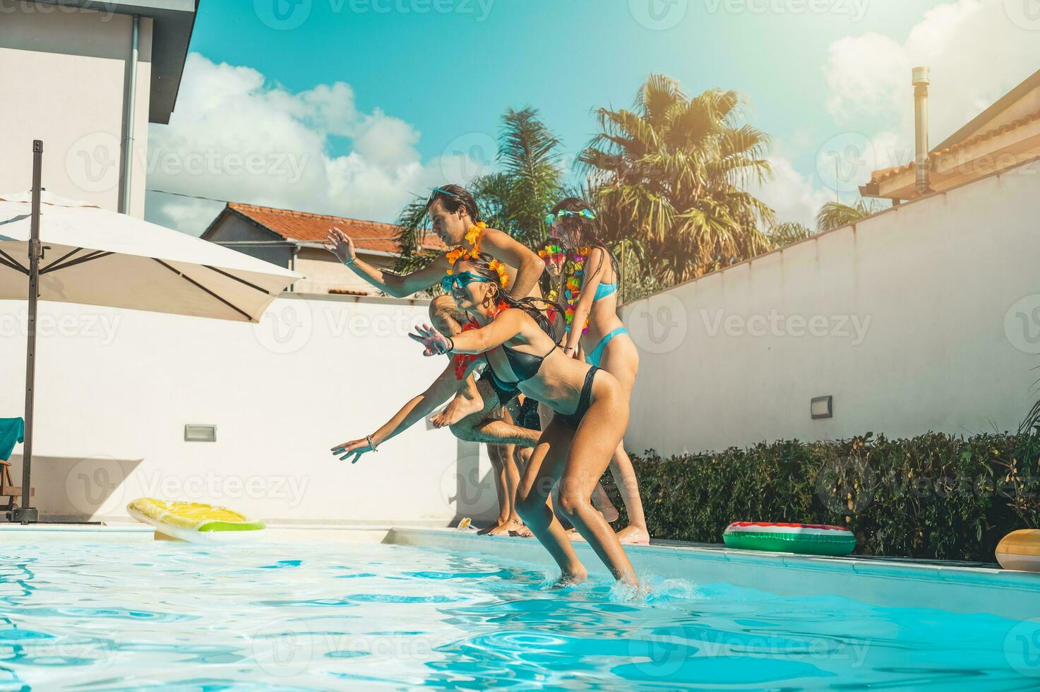 grupo do amigos dentro roupa de banho apreciar dentro uma natação piscina foto