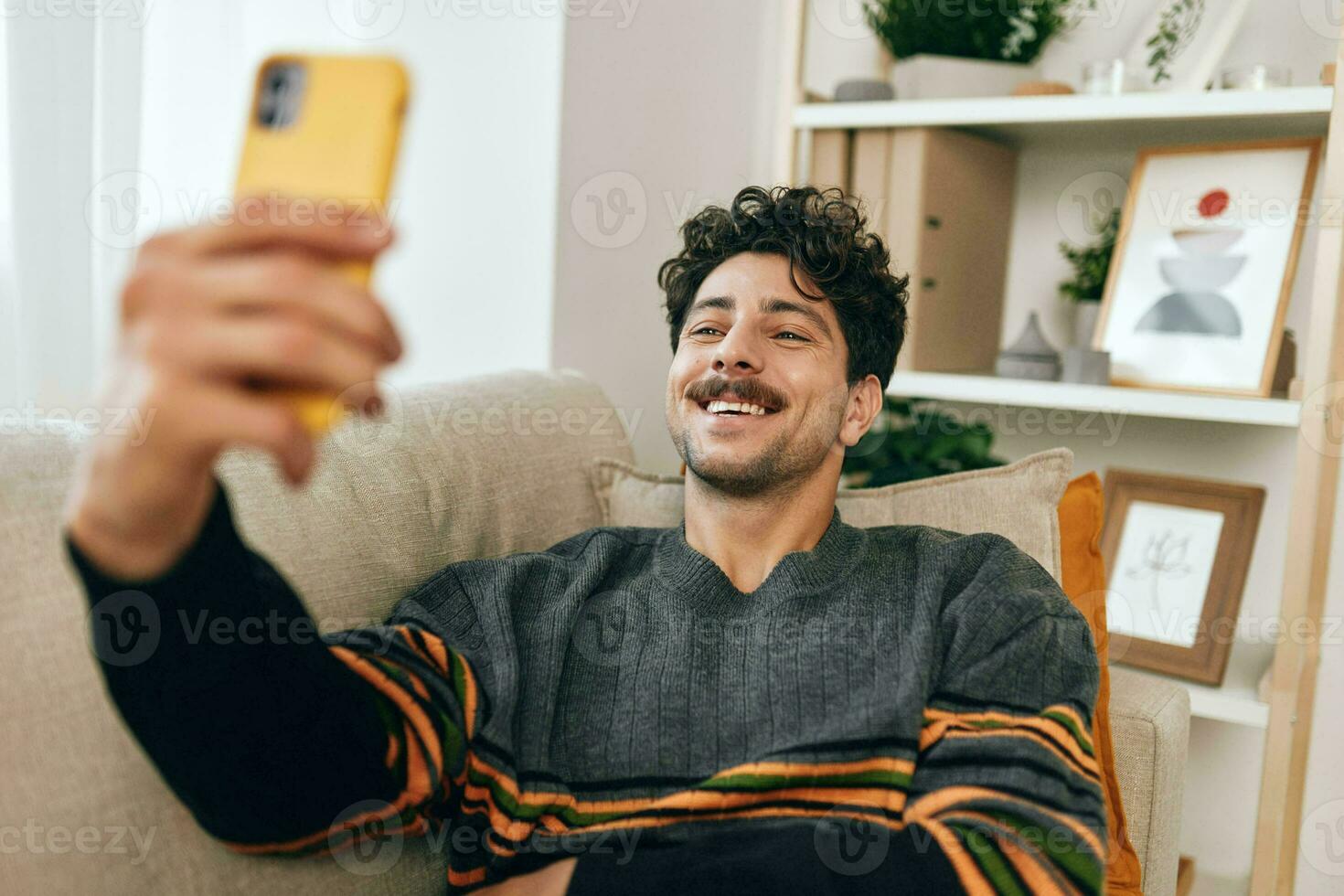 homem digitando quarto vivo selfie casa sentado estilo de vida sofá mensagem telefone comunicação tecnologia foto
