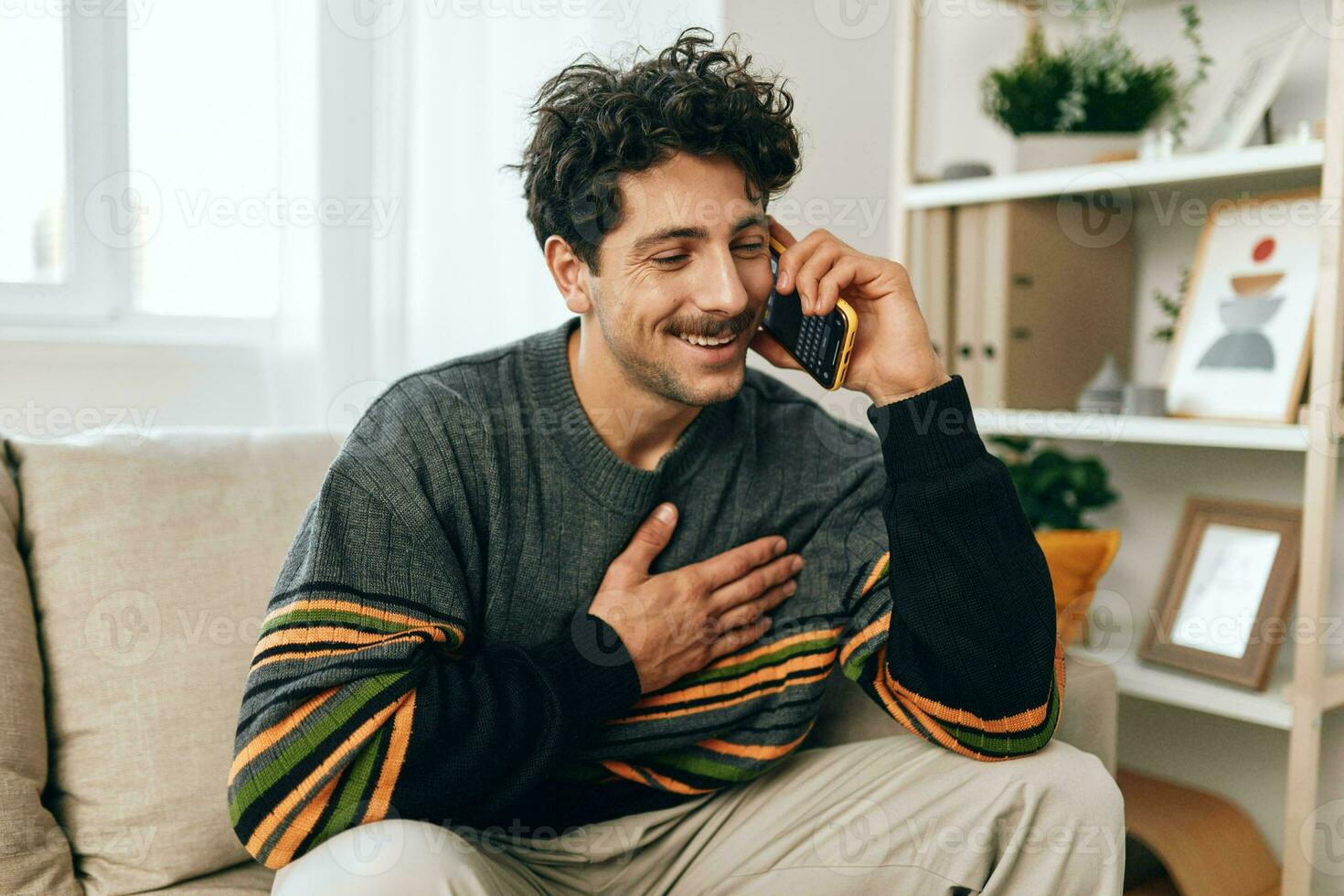 homem telefone célula estilo de vida casa sentado sofá sorrir foto