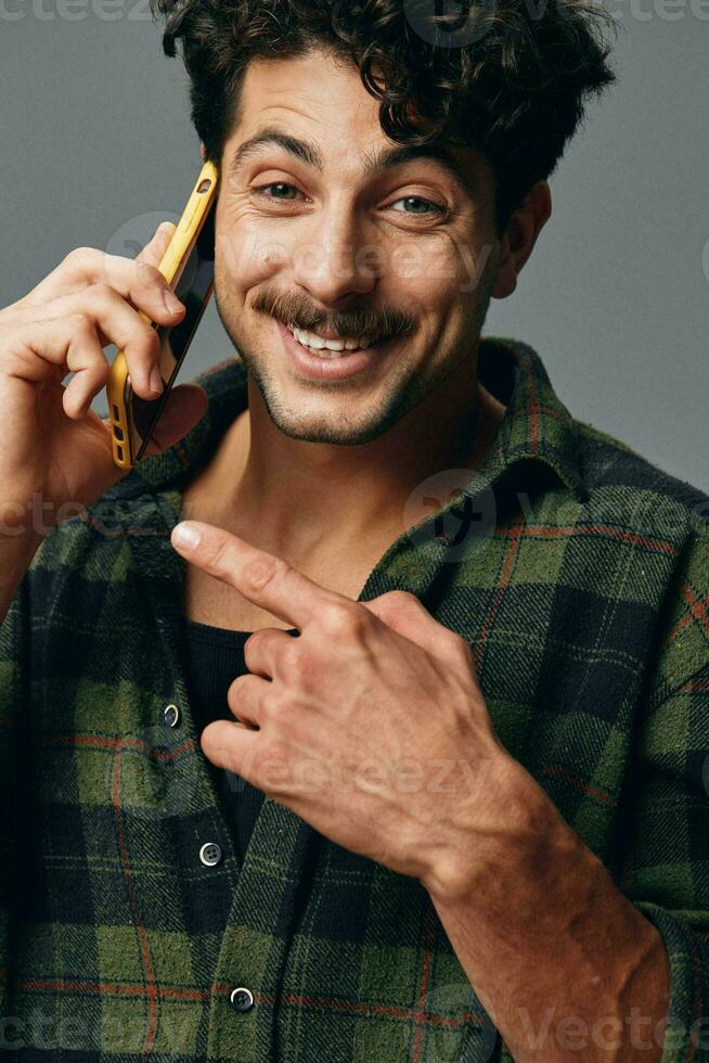 homem cinzento camisa caucasiano sorrir feliz estúdio tecnologia telefone fundo estilo de vida face à moda foto