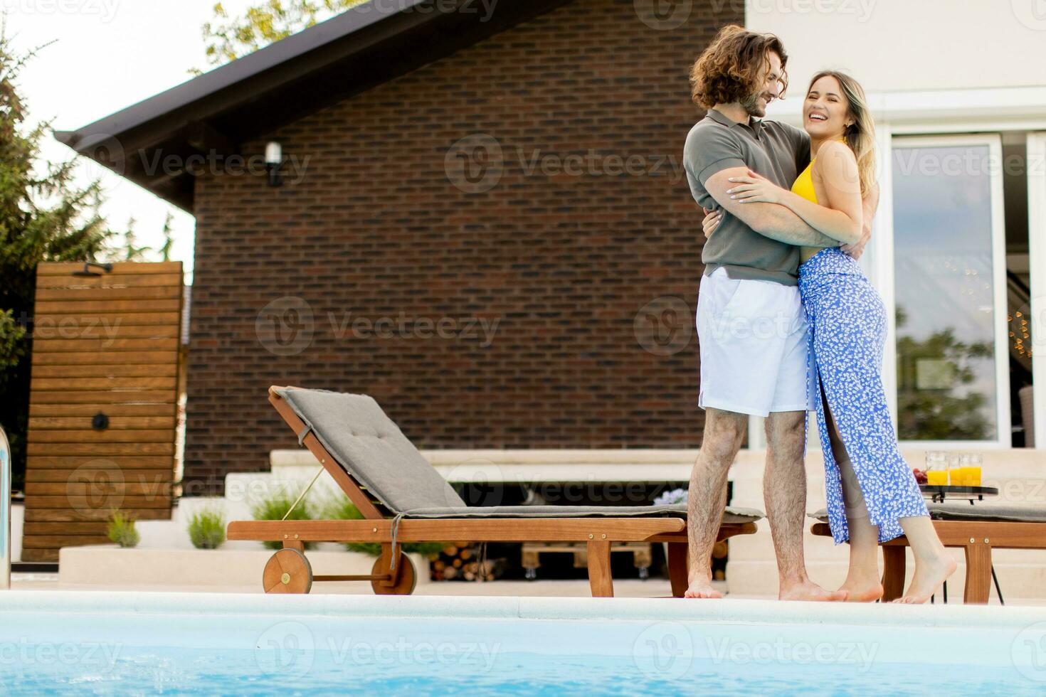 jovem casal relaxante de a natação piscina dentro a casa quintal foto