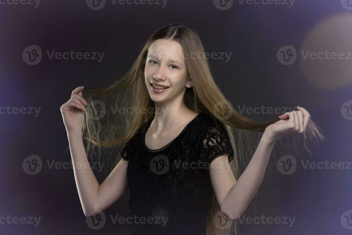 Adolescência menina com grandes cabelo dentro uma Preto vestir em uma fundo do colori bokeh. foto