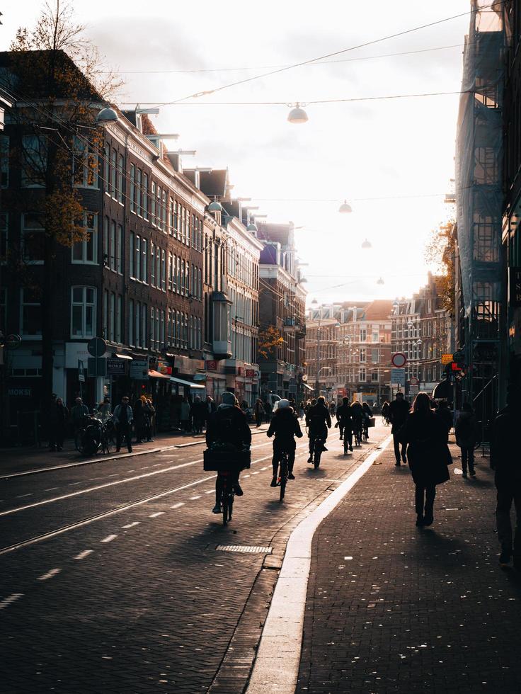 amsterdam, holanda 2018- ciclistas andando nas ruas com pedestres na calçada em amsterdã foto