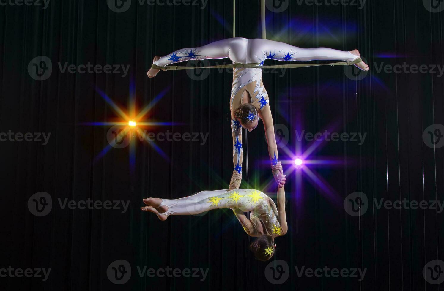 circo acrobatas ginastas executar em uma etapa Sombrio fundo. foto