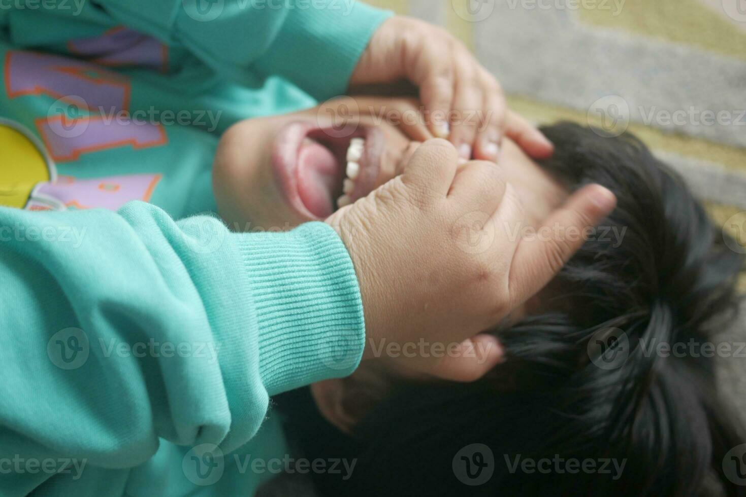 uma chateado criança menina cobrir dela face com mão foto