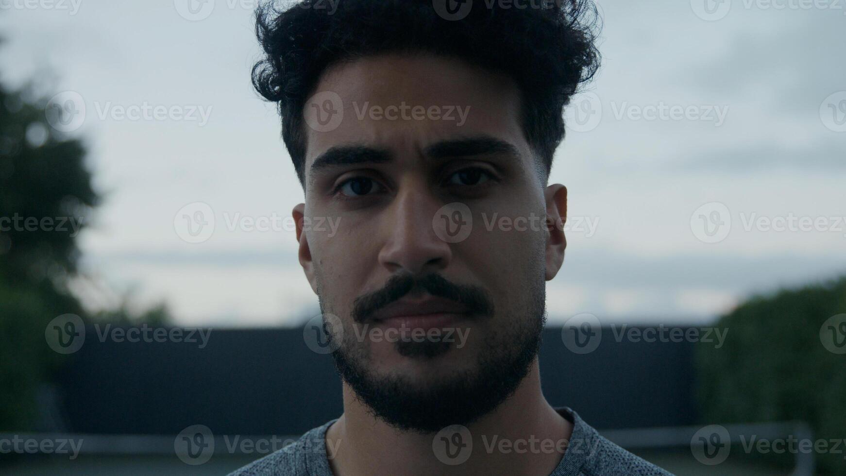 jovem com bigode e barba olhando para a câmera foto