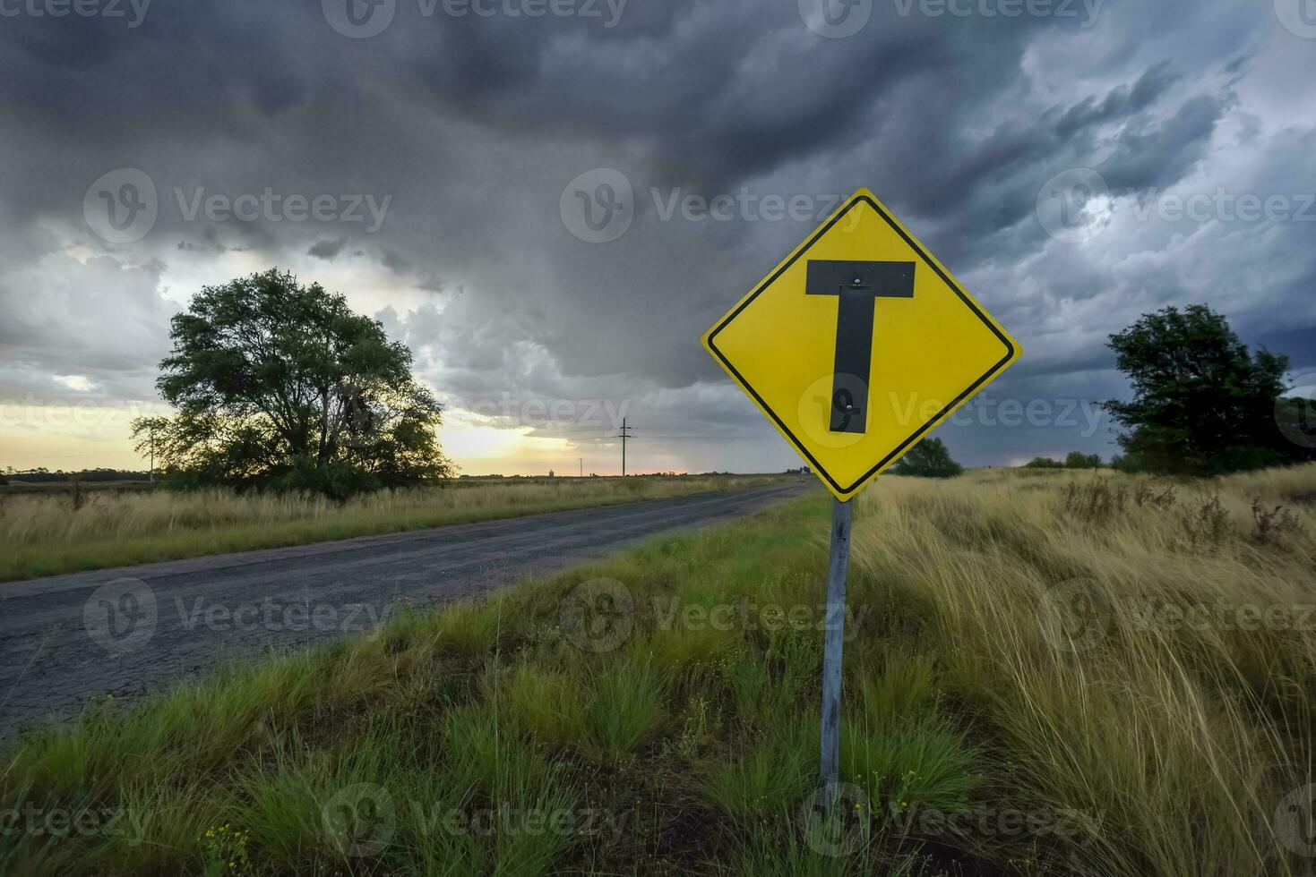 estrada cruzando Atenção placa com uma tormentoso céu fundo, la pampa província, Patagônia, Argentina. foto