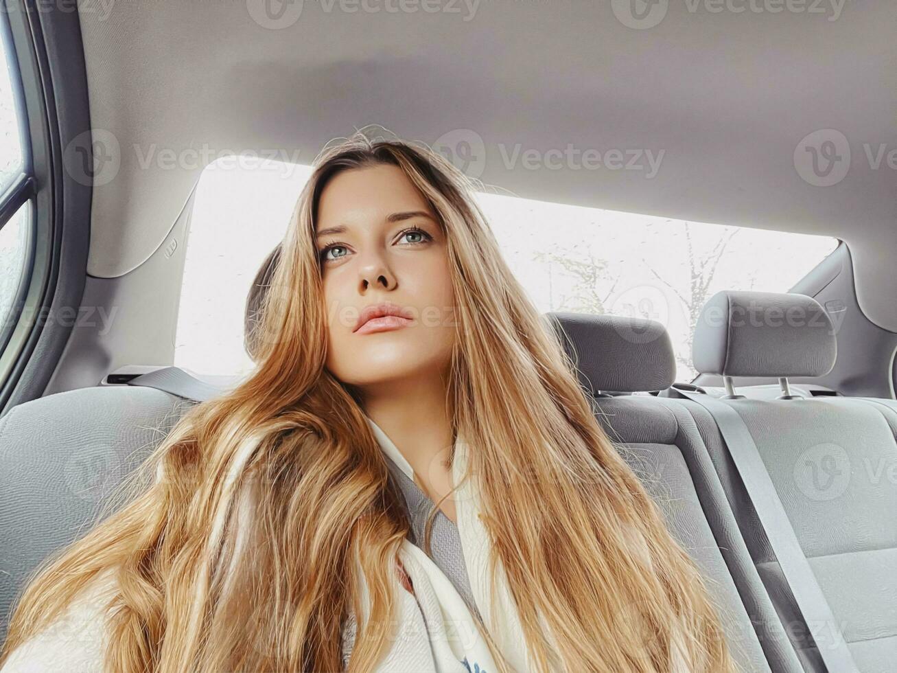 jovem mulher com grandes cabelo, ondulado Penteado dentro a carro ou Táxi táxi Como passageiro, explorando a cidade, transporte e viagem foto