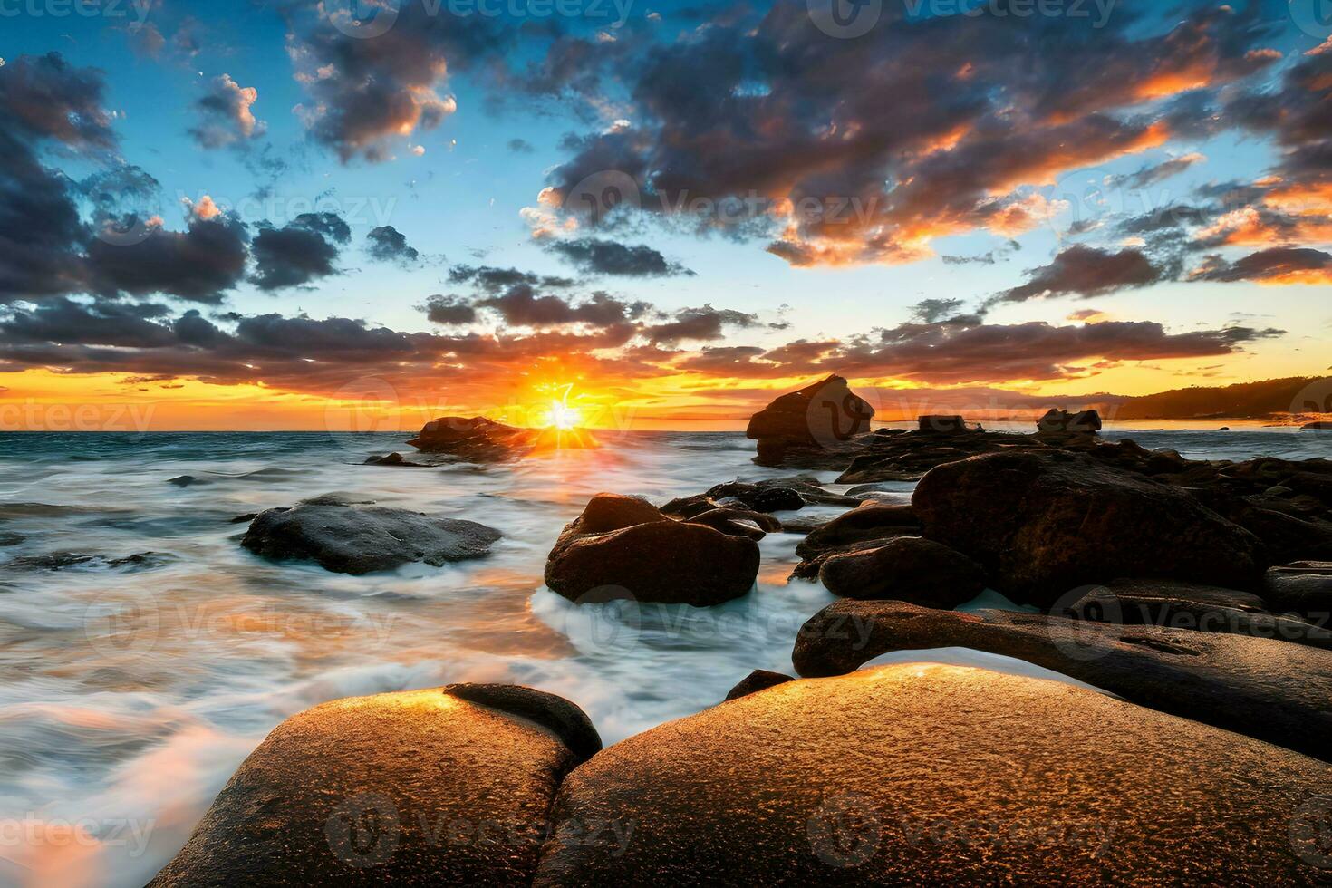 ondas e pedras na praia do pôr do sol foto