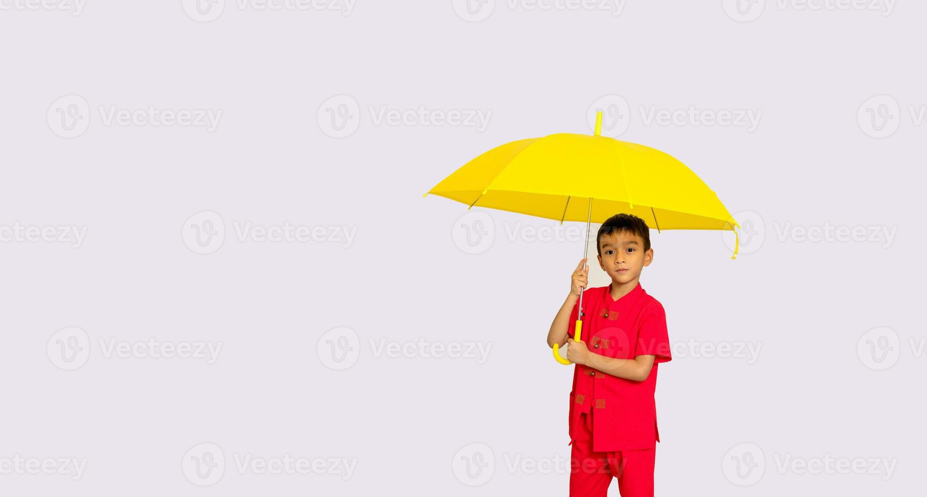 Garoto moda vestindo uma estilo chinês camisa segurando uma amarelo guarda-chuva poses para uma foto atirar.