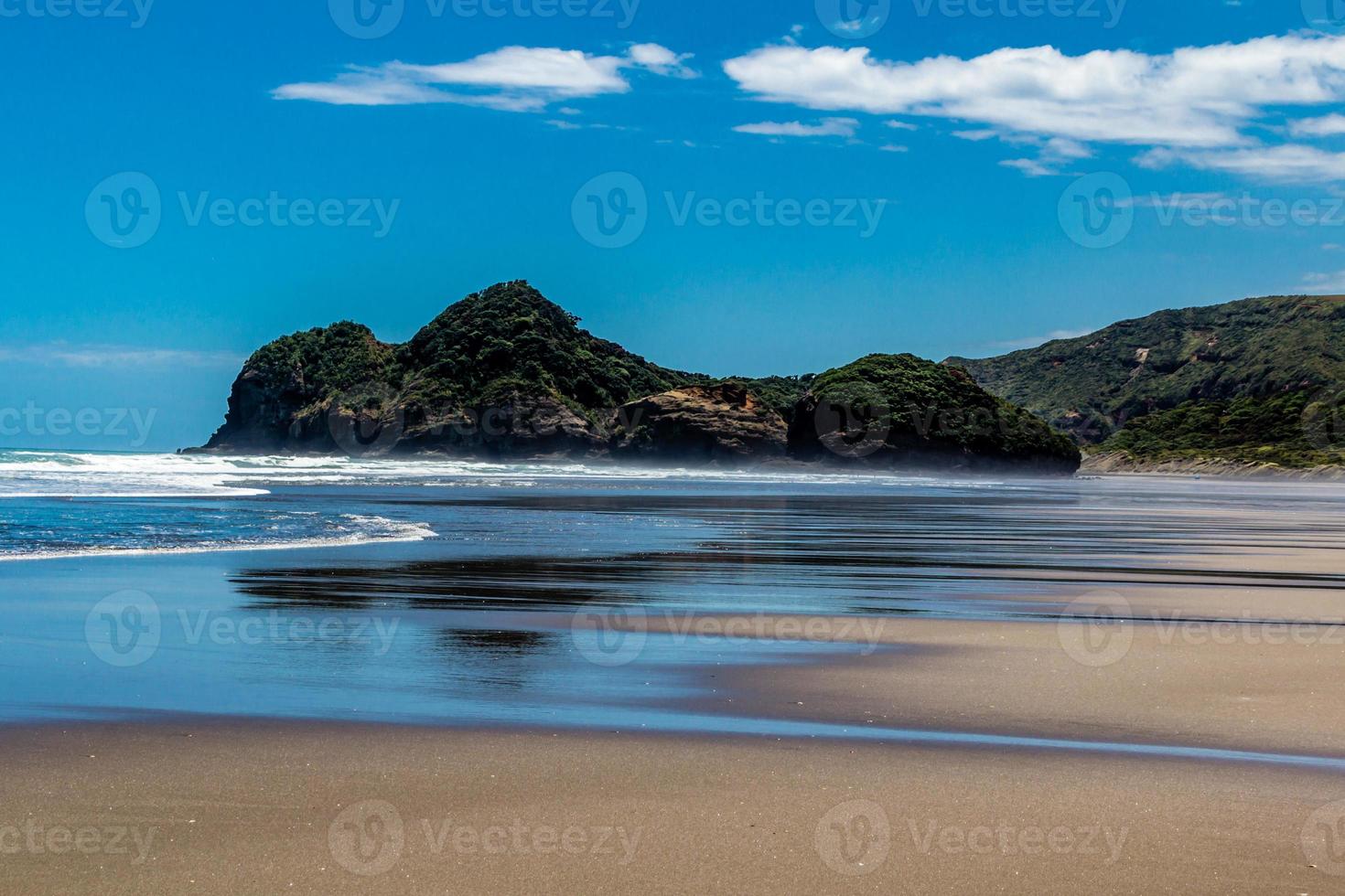 praias de areia, falésias e água corrente na praia de bethels. Auckland, Nova Zelândia foto