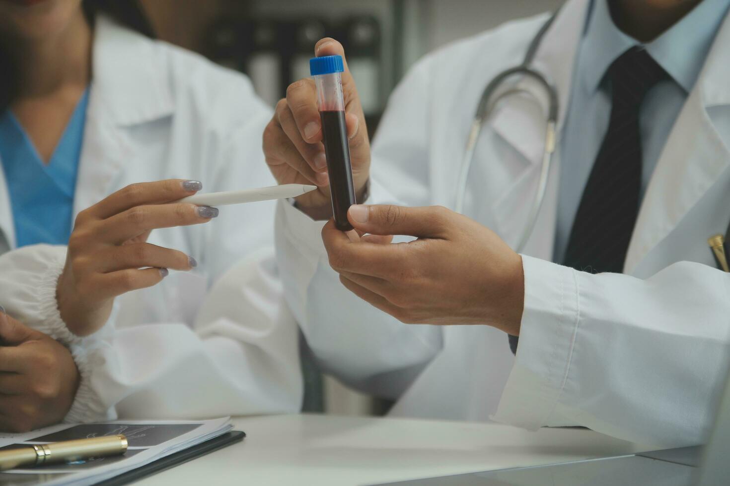 médico sentado às escrivaninha e escrevendo uma prescrição para dela paciente foto