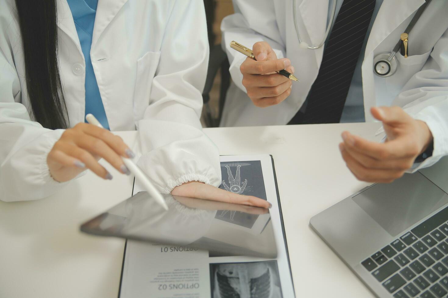 médico sentado às escrivaninha e escrevendo uma prescrição para dela paciente foto